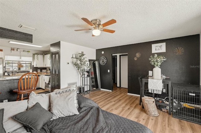 3881 Holin Ln, North Port, FL 34287 - living area featuring light wood-style flooring, a ceiling fan, and a textured ceiling