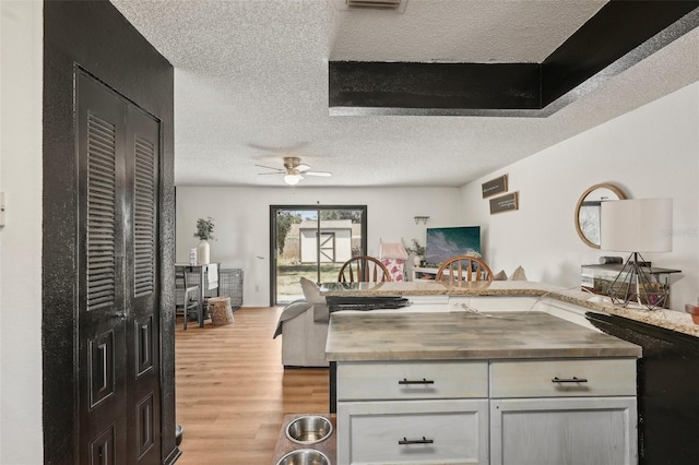 3881 Holin Ln, North Port, FL 34287 - kitchen featuring wooden counters, a textured ceiling, light wood-type flooring, ceiling fan, and open floor plan