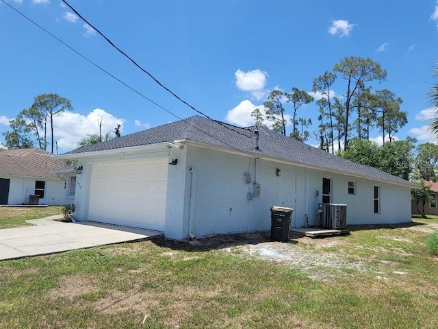 1422 Jakway Rd, North Port, FL 34288 - rear view of property featuring a garage, concrete driveway, central air condition unit, and a lawn