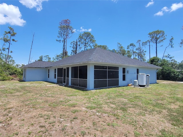 1422 Jakway Rd, North Port, FL 34288 - rear view of house featuring a sunroom, a lawn, and stucco siding