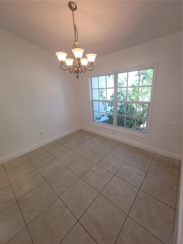 1422 Jakway Rd, North Port, FL 34288 - spare room with a chandelier, light tile patterned floors, and baseboards
