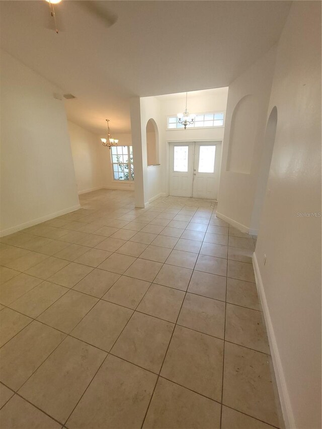 1422 Jakway Rd, North Port, FL 34288 - foyer entrance featuring a chandelier, light tile patterned flooring, baseboards, and arched walkways