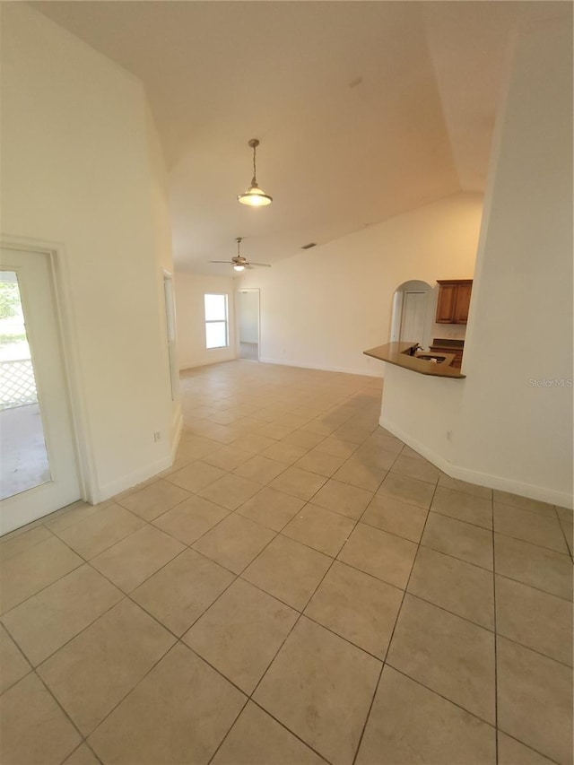 1422 Jakway Rd, North Port, FL 34288 - unfurnished living room featuring light tile patterned flooring, vaulted ceiling, a sink, baseboards, and ceiling fan