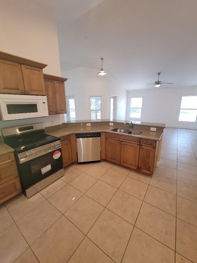 1422 Jakway Rd, North Port, FL 34288 - kitchen featuring stainless steel appliances, a sink, light tile patterned floors, healthy amount of natural light, and vaulted ceiling