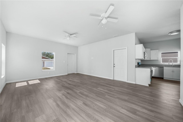 703 Salamanca Ct, Sebring, FL 33870 - unfurnished living room with a sink, ceiling fan, dark wood-style floors, and baseboards
