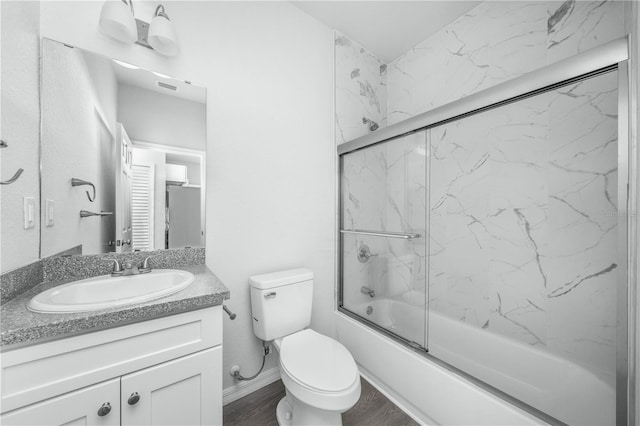 703 Salamanca Ct, Sebring, FL 33870 - full bath with vanity, combined bath / shower with glass door, toilet, and wood finished floors