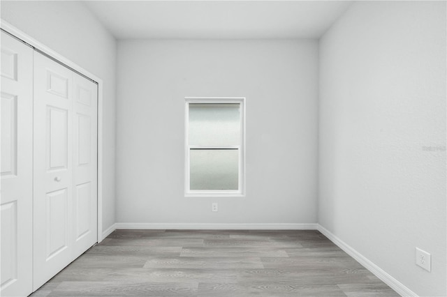 703 Salamanca Ct, Sebring, FL 33870 - unfurnished bedroom with wood finished floors, a closet, and baseboards