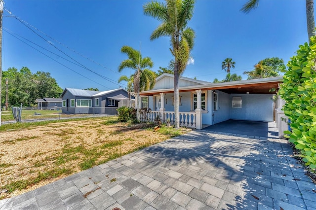 513 25th Ave W, Bradenton, FL 34205 - view of front of property featuring a porch, decorative driveway, a carport, and stucco siding