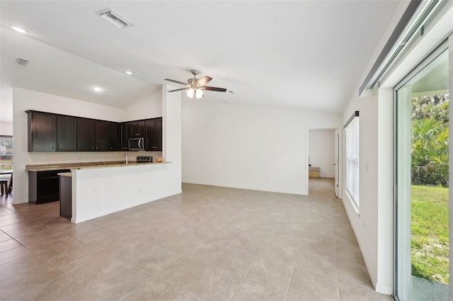4091 Dull St, North Port, FL 34286 - kitchen featuring vaulted ceiling, stainless steel microwave, open floor plan, a ceiling fan, and light countertops