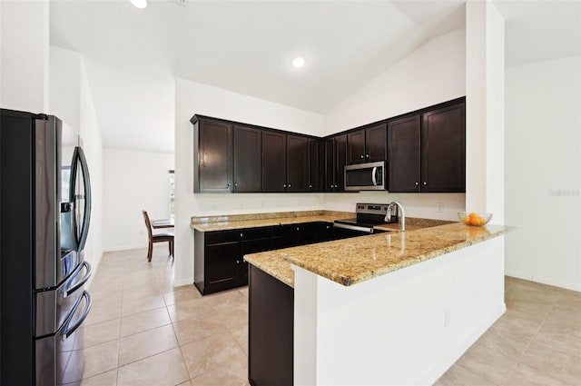 4091 Dull St, North Port, FL 34286 - kitchen with stainless steel appliances, vaulted ceiling, a peninsula, light stone counters, and light tile patterned floors