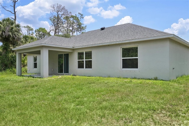 4091 Dull St, North Port, FL 34286 - rear view of property with stucco siding, a shingled roof, and a yard