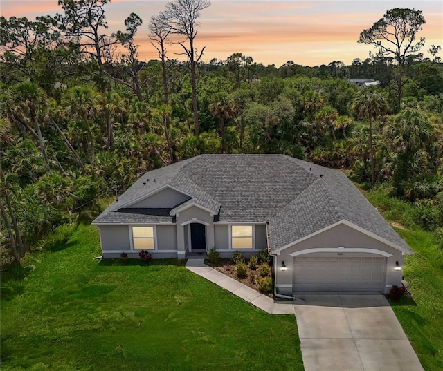4091 Dull St, North Port, FL 34286 - ranch-style home featuring a garage, driveway, a lawn, roof with shingles, and stucco siding
