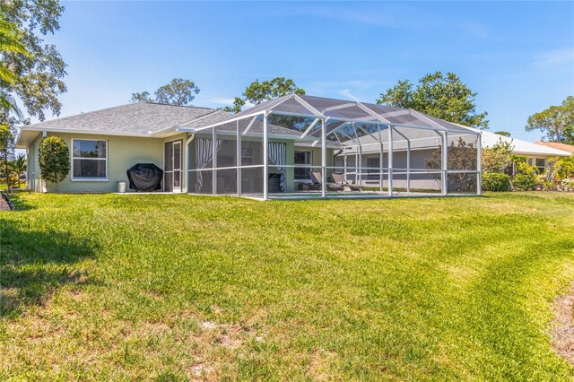 4758 Breezy Pines Blvd, Sarasota, FL 34232 - rear view of house with a yard, stucco siding, and glass enclosure