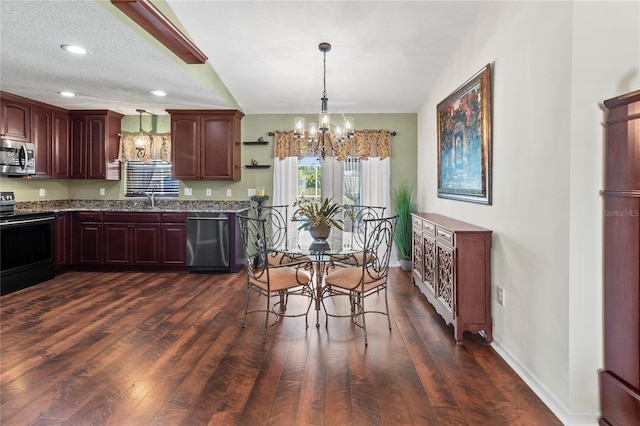 4758 Breezy Pines Blvd, Sarasota, FL 34232 - kitchen with stainless steel appliances, a chandelier, dark wood finished floors, light stone counters, and baseboards
