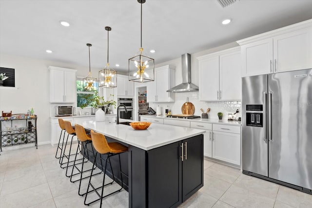 26000 Seastone Dr, Englewood, FL 34223 - kitchen with stainless steel appliances, wall chimney exhaust hood, light tile patterned floors, tasteful backsplash, and recessed lighting