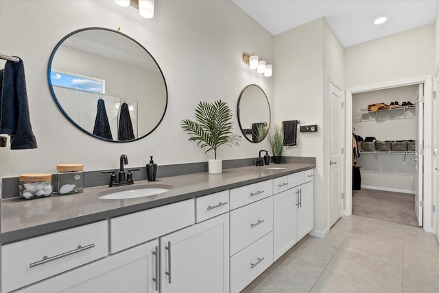 26000 Seastone Dr, Englewood, FL 34223 - bathroom featuring double vanity, a walk in closet, recessed lighting, and tile patterned floors