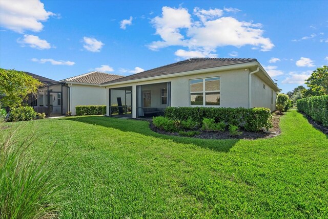 26000 Seastone Dr, Englewood, FL 34223 - rear view of property featuring stucco siding, a yard, and a tiled roof