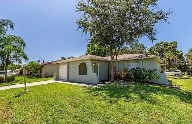 8730 Filson Pl, Sarasota, FL 34231 - view of front facade featuring an attached garage, a front yard, driveway, and stucco siding
