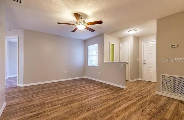 8730 Filson Pl, Sarasota, FL 34231 - spare room with a ceiling fan, wood finished floors, a textured ceiling, and baseboards