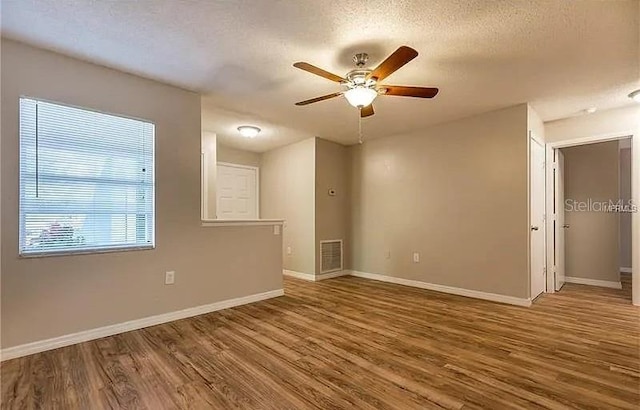 8730 Filson Pl, Sarasota, FL 34231 - unfurnished room with a ceiling fan, wood finished floors, baseboards, and a textured ceiling