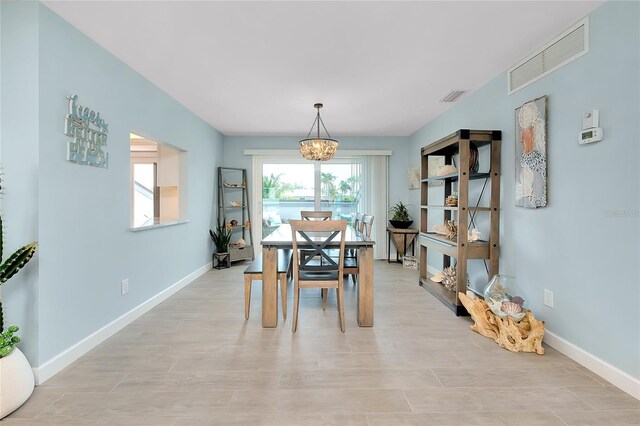 1001 Point Of Rocks Rd Unit 207, Sarasota, FL 34242 - dining room featuring a chandelier and baseboards