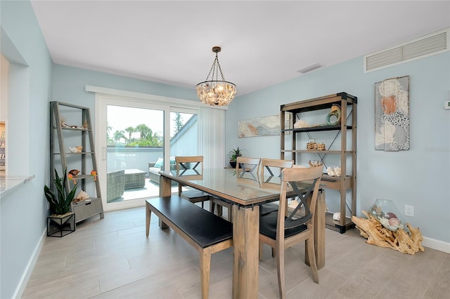 1001 Point Of Rocks Rd Unit 207, Sarasota, FL 34242 - dining room featuring a chandelier, light wood finished floors, and baseboards