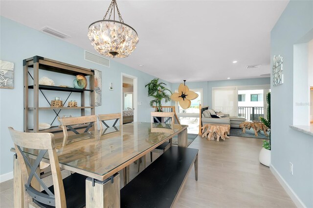 1001 Point Of Rocks Rd Unit 207, Sarasota, FL 34242 - dining area with a chandelier, baseboards, and light wood-type flooring