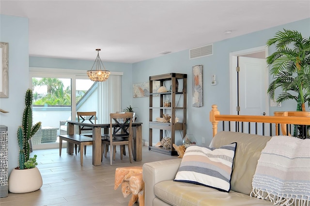1001 Point Of Rocks Rd Unit 207, Sarasota, FL 34242 - living area featuring a chandelier and light wood-style floors