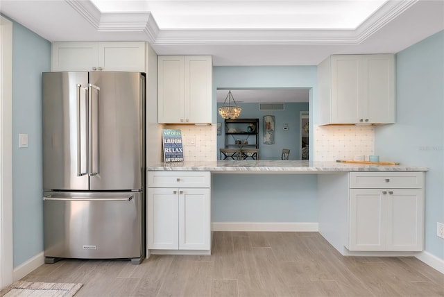 1001 Point Of Rocks Rd Unit 207, Sarasota, FL 34242 - kitchen featuring freestanding refrigerator, light wood-type flooring, tasteful backsplash, white cabinetry, and crown molding