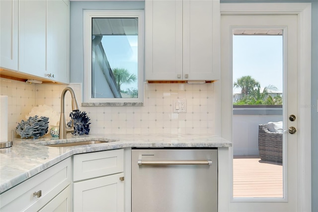 1001 Point Of Rocks Rd Unit 207, Sarasota, FL 34242 - kitchen with stainless steel dishwasher, a sink, backsplash, and white cabinets