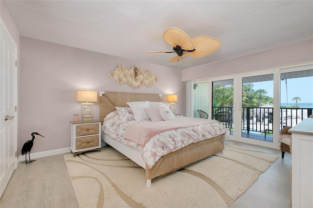 1001 Point Of Rocks Rd Unit 207, Sarasota, FL 34242 - bedroom featuring access to exterior, light wood finished floors, baseboards, and a ceiling fan
