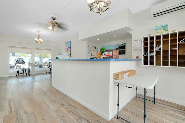 1001 Point Of Rocks Rd Unit 207, Sarasota, FL 34242 - kitchen featuring a wall unit AC, a chandelier, light wood-type flooring, and baseboards