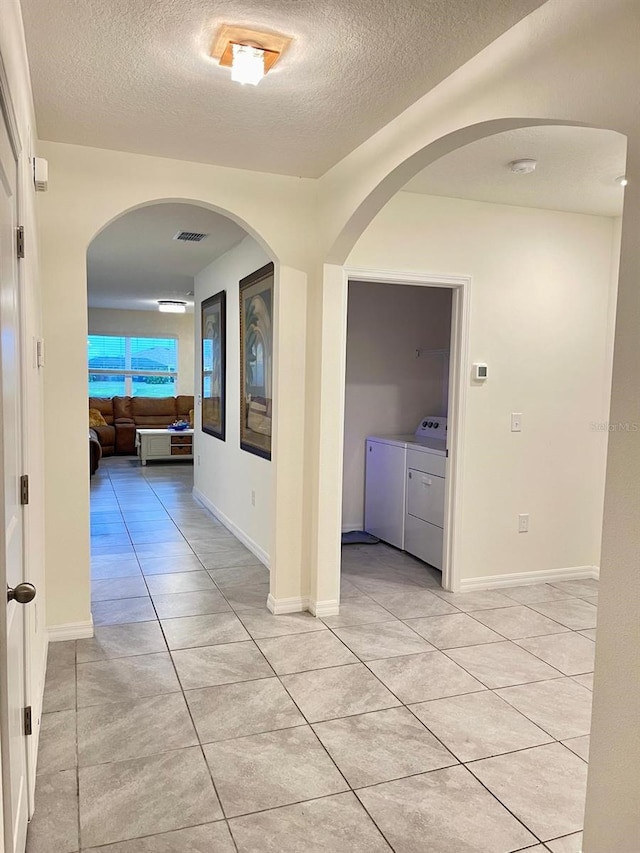 2410 Mizner Bay Ave, Bradenton, FL 34208 - corridor featuring independent washer and dryer, a textured ceiling, and light tile patterned floors
