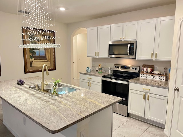 2410 Mizner Bay Ave, Bradenton, FL 34208 - kitchen featuring appliances with stainless steel finishes, a sink, arched walkways, and white cabinets