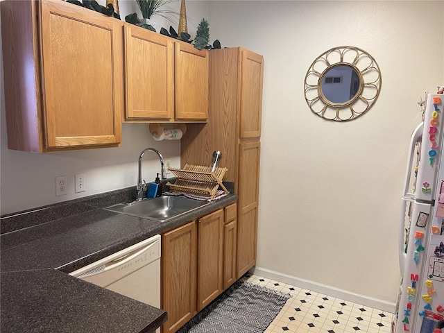 4802 51st St W Unit 1724, Bradenton, FL 34210 - kitchen featuring white appliances, a sink, baseboards, light flooring, and dark countertops