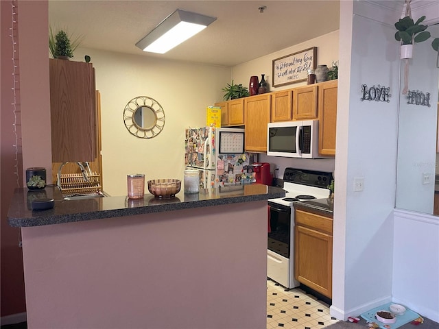4802 51st St W Unit 1724, Bradenton, FL 34210 - kitchen featuring white appliances, dark countertops, a peninsula, light floors, and brown cabinets