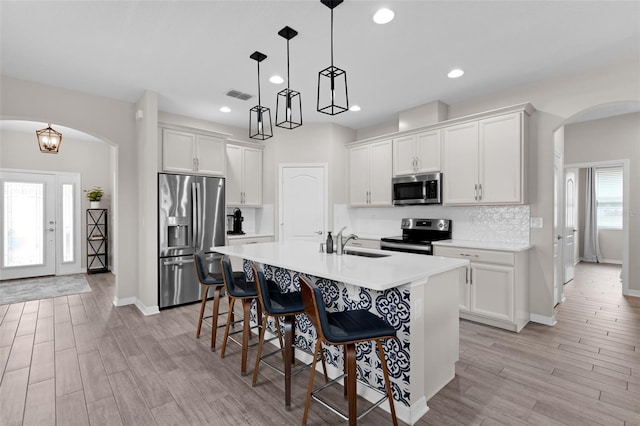 1896 Napoli Dr, Saint Cloud, FL 34771 - kitchen featuring stainless steel appliances, a sink, arched walkways, a breakfast bar area, and recessed lighting