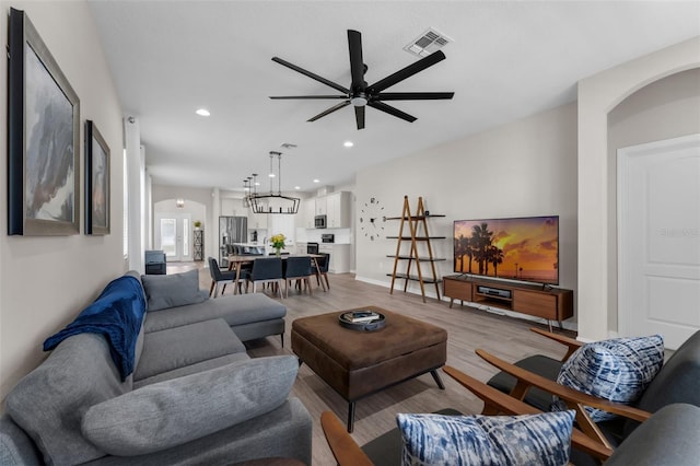 1896 Napoli Dr, Saint Cloud, FL 34771 - living area with arched walkways, light wood-style floors, ceiling fan, and recessed lighting