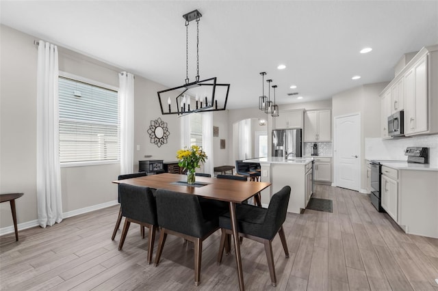 1896 Napoli Dr, Saint Cloud, FL 34771 - dining space with light wood-style floors, arched walkways, baseboards, recessed lighting, and a chandelier