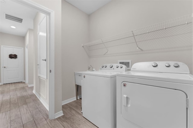 1896 Napoli Dr, Saint Cloud, FL 34771 - laundry room with washer and clothes dryer, light wood-style floors, and baseboards