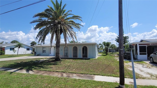 6360 Jordan St, North Port, FL 34287 - ranch-style house with a front yard, a sunroom, stucco siding, and concrete driveway