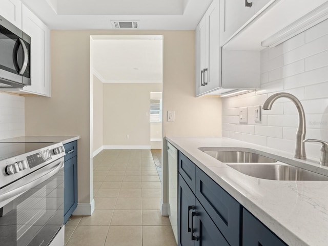 6300 Midnight Pass Rd Unit 5, Sarasota, FL 34242 - kitchen featuring a sink, appliances with stainless steel finishes, tasteful backsplash, white cabinetry, and light tile patterned flooring