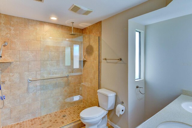 8402 13th Ave NW, Bradenton, FL 34209 - bathroom featuring tiled shower, toilet, plenty of natural light, and double vanity
