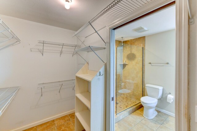 8402 13th Ave NW, Bradenton, FL 34209 - full bath with toilet, a stall shower, tile patterned flooring, a walk in closet, and baseboards