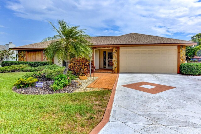 8402 13th Ave NW, Bradenton, FL 34209 - ranch-style home featuring driveway, an attached garage, stone siding, and a front yard