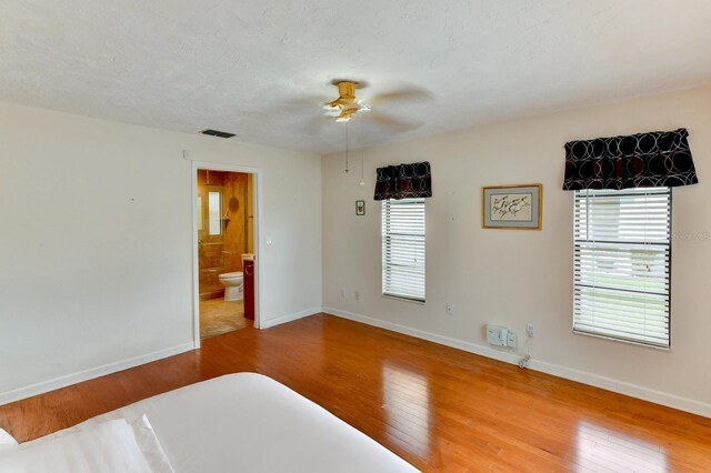 8402 13th Ave NW, Bradenton, FL 34209 - unfurnished bedroom featuring wood finished floors, baseboards, ensuite bath, and ceiling fan