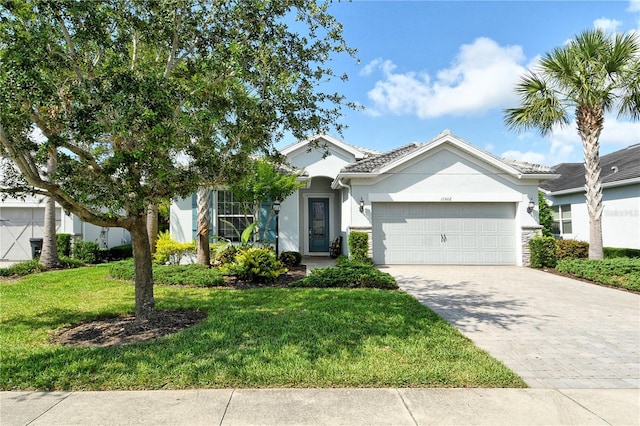 11502 Golden Bay Pl, Bradenton, FL 34211 - ranch-style home featuring an attached garage, decorative driveway, stucco siding, and a front lawn