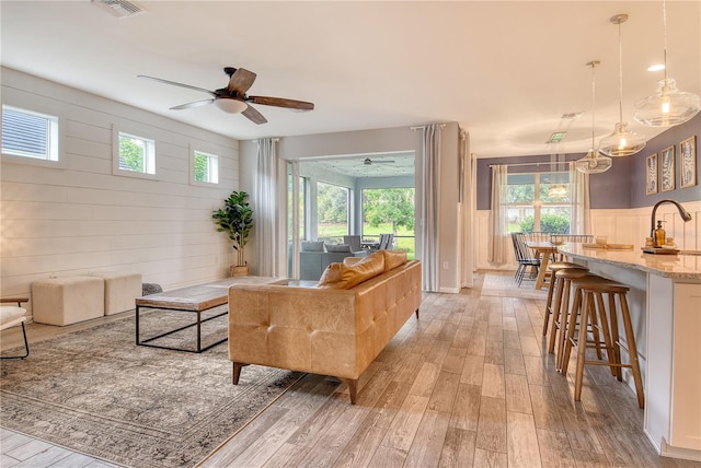 11502 Golden Bay Pl, Bradenton, FL 34211 - living area featuring light wood finished floors, a ceiling fan, and wood walls