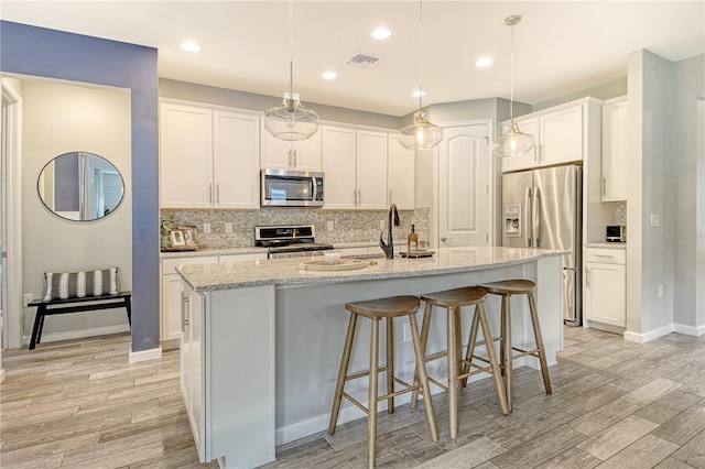 11502 Golden Bay Pl, Bradenton, FL 34211 - kitchen with stainless steel appliances, a sink, light wood finished floors, decorative backsplash, and recessed lighting