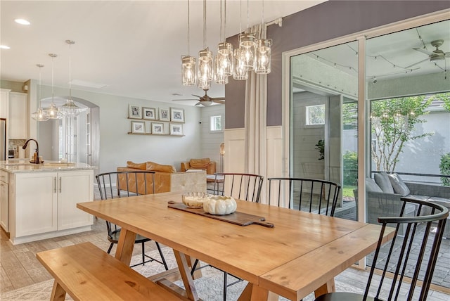 11502 Golden Bay Pl, Bradenton, FL 34211 - dining space featuring a ceiling fan, light wood finished floors, a chandelier, arched walkways, and recessed lighting